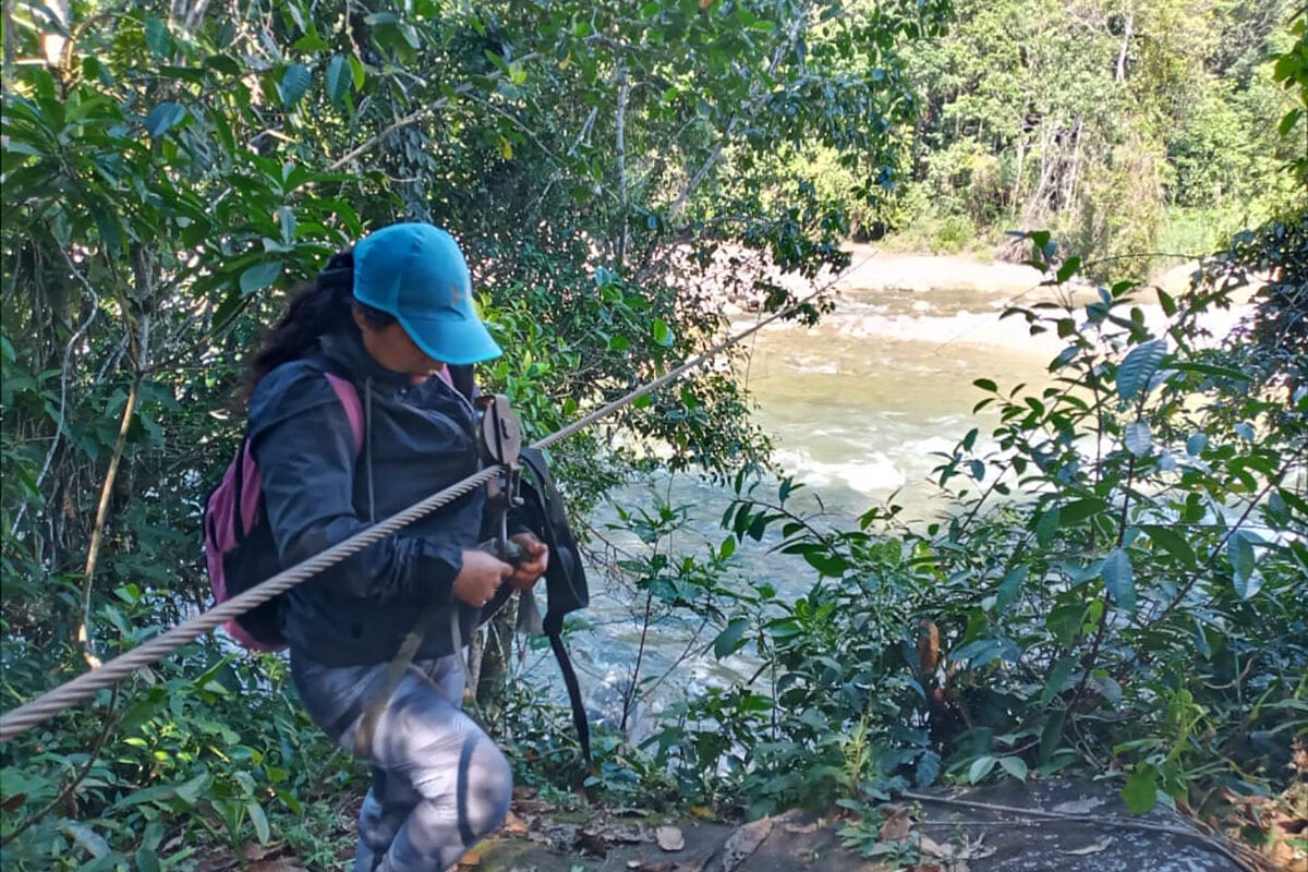 Edelmira, cacaoultrice Treegether au Pérou, s'attache à la tyrolienne qui lui permet de rejoindre sa plantation.